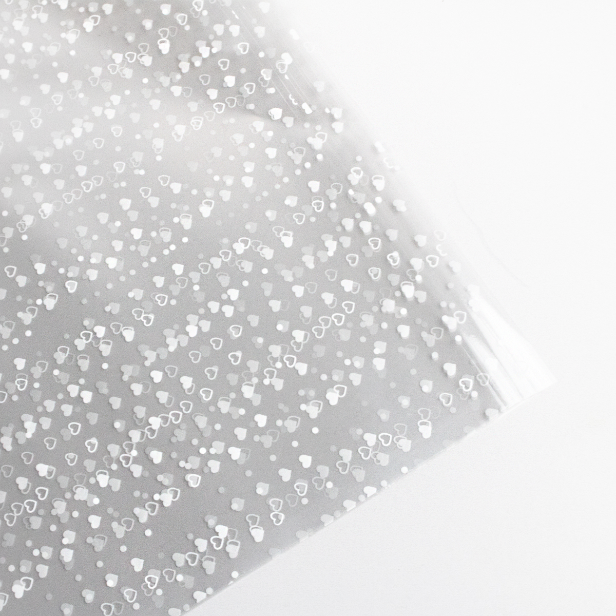 Papel celofan con diseño de patrón de corazones blancos